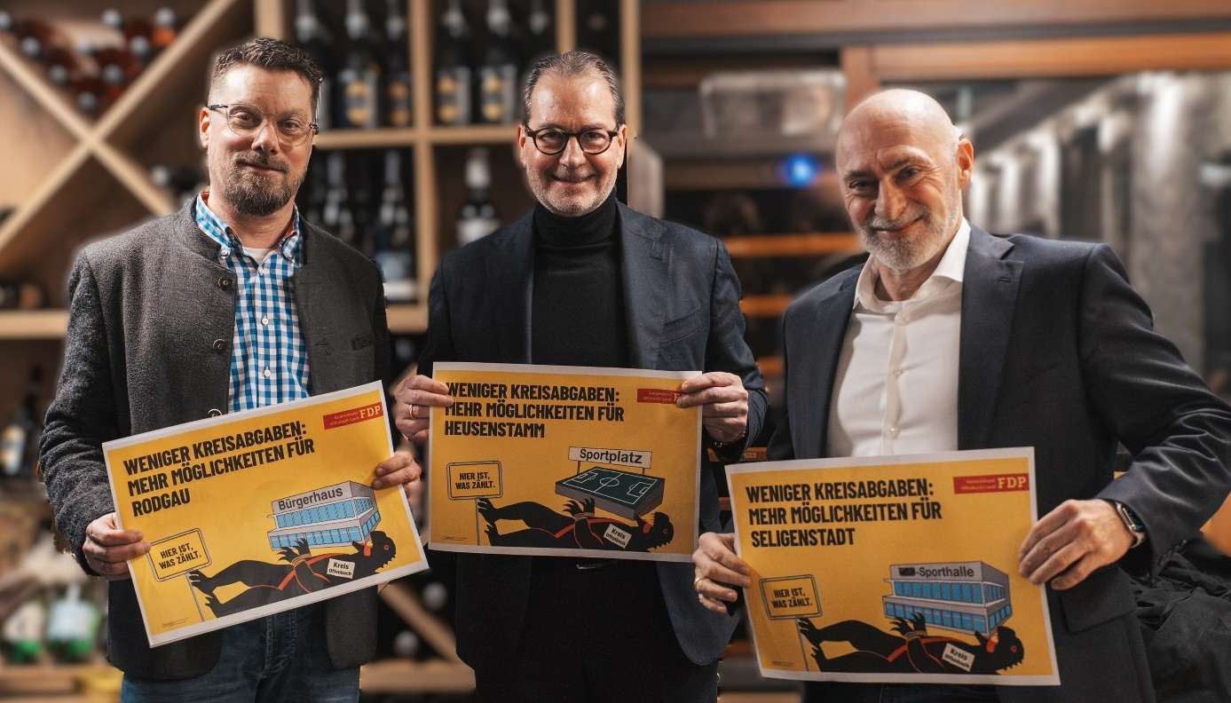 Michael Schüßler, Ernestos Varvaroussis und Rene Rock stehen nebeneinander und halten ein Kreiszilla Plakat der FDP hoch